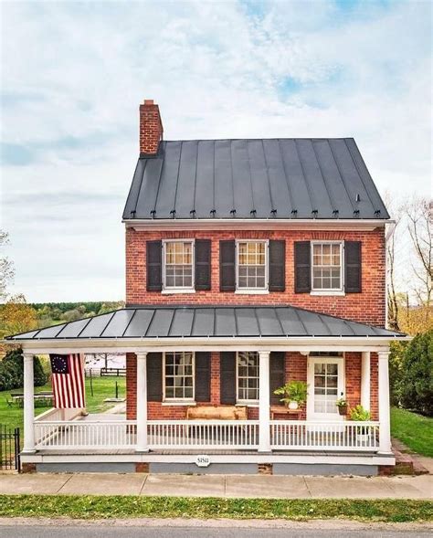 red brick house with black metal roof|red brick house black shutters.